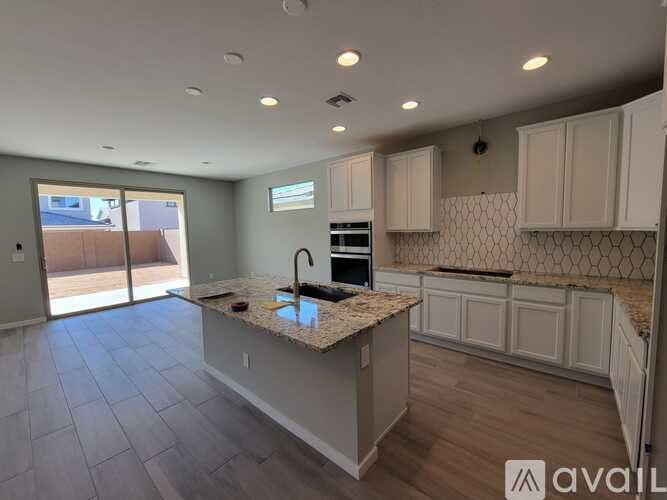 A kitchen with a granite countertop and white cabinets.