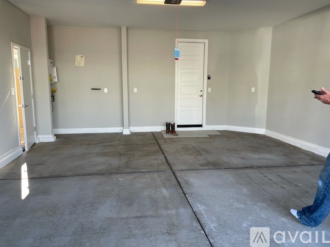 A person is standing in a room with a concrete floor and white walls.