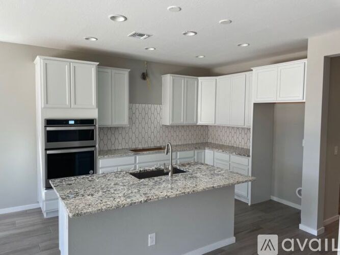 A kitchen with granite countertops and white cabinets.