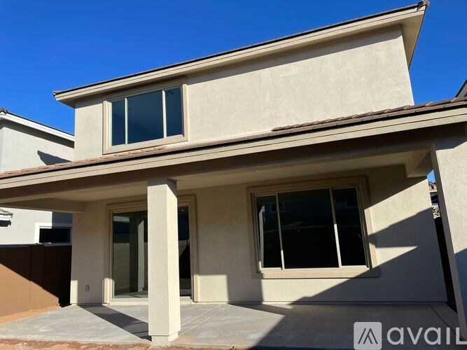 A modern house with a beige facade and large windows.