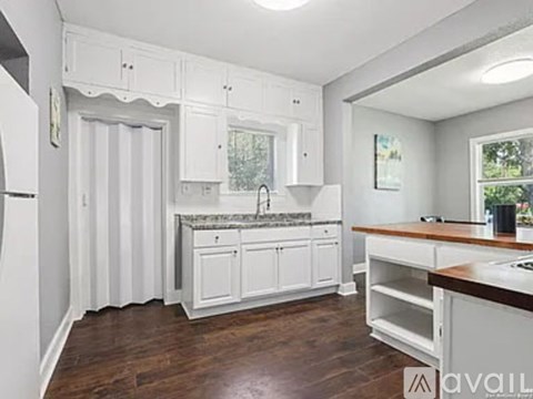 A kitchen with white cabinets and a wooden countertop.
