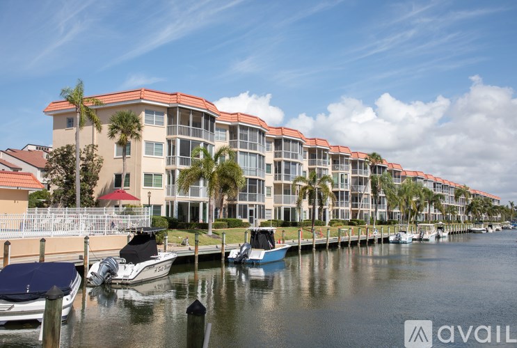 A row of houses with boats in front of them.