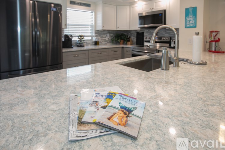 A kitchen with a granite countertop and a refrigerator.