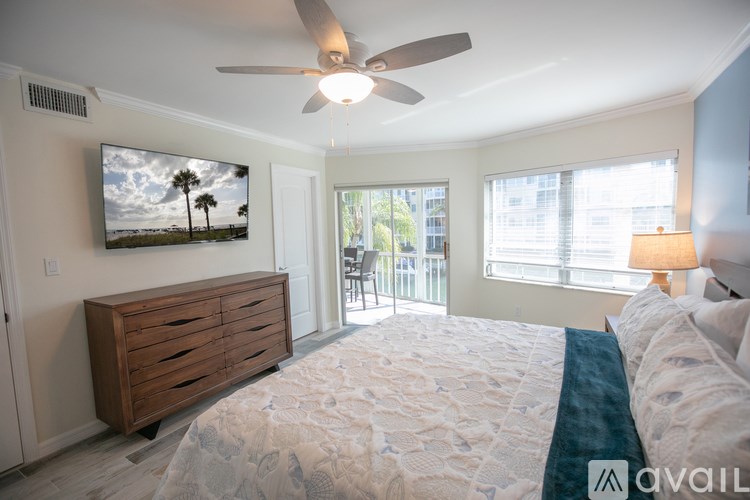 A bedroom with a large bed and a flat screen TV mounted on the wall.