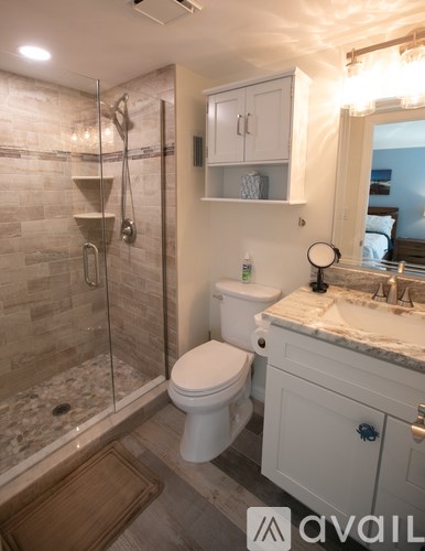 A bathroom with a toilet, sink, and shower.