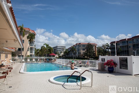 A woman is sitting on a chair by a small pool.