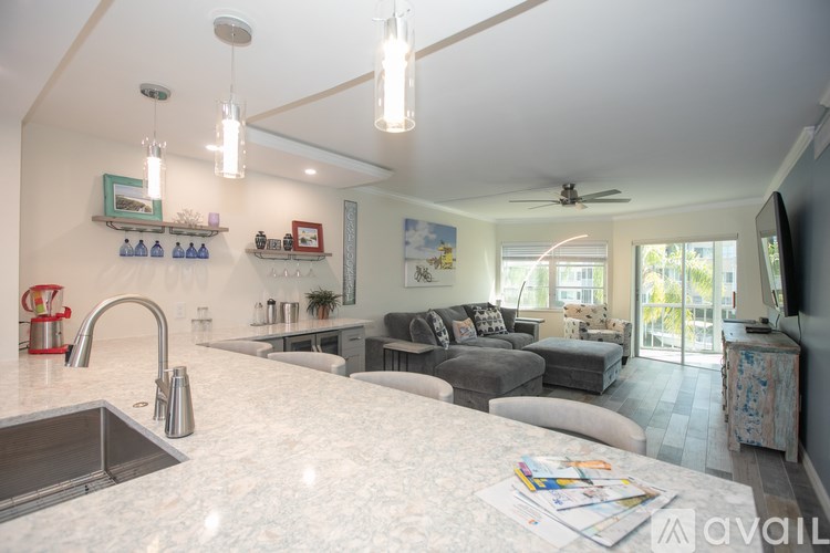 A modern kitchen with a marble countertop and a sink.