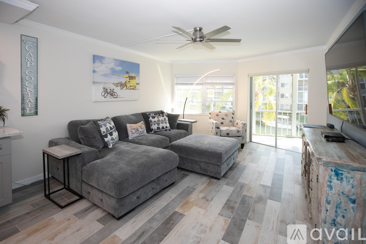 A living room with a grey couch and a ceiling fan.