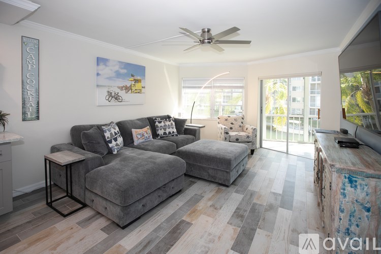 A living room with a grey couch and a ceiling fan.
