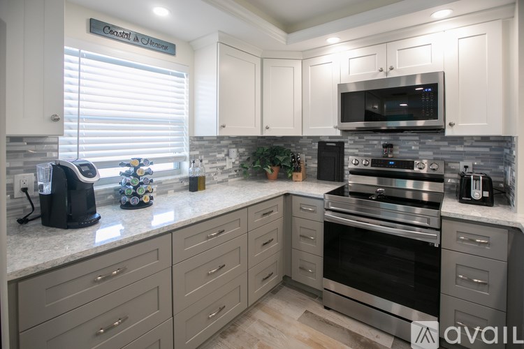 A kitchen with a granite countertop and stainless steel appliances.
