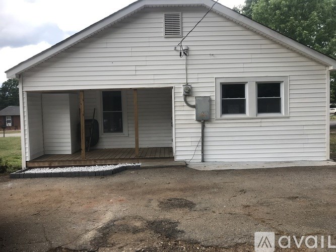 A white house with a garage door open and a window on the side.