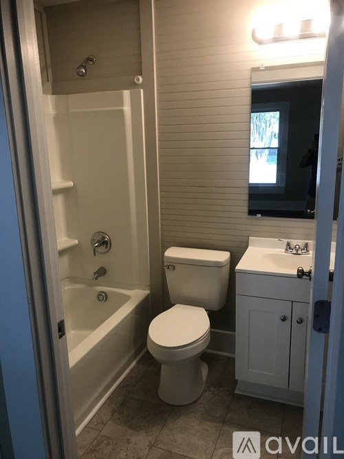 A bathroom with a toilet, sink, and bathtub.