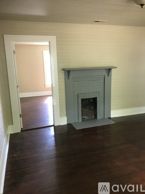 A room with a fireplace and wooden floors.