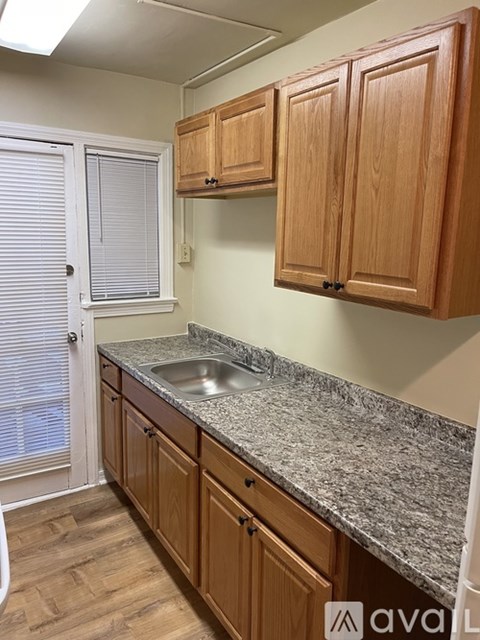 A kitchen with wooden cabinets and granite countertops.