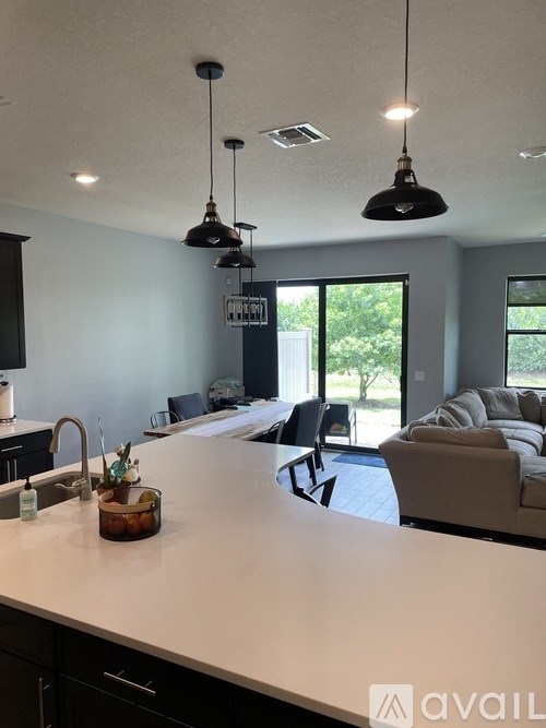 A kitchen with a white counter top and black cabinets.