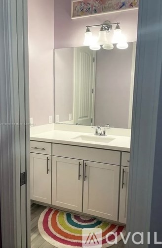 A bathroom with a white sink and cabinets.