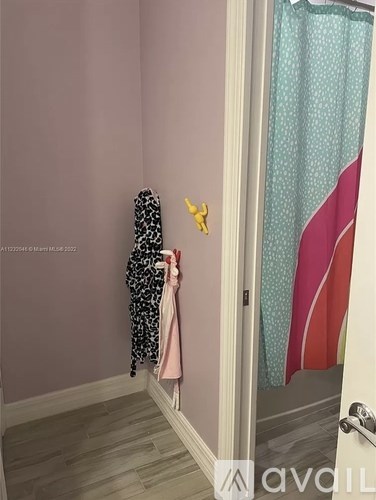 A child's towel hanging on a door handle.