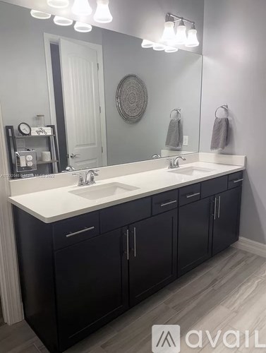 A bathroom with two sinks and a large mirror.