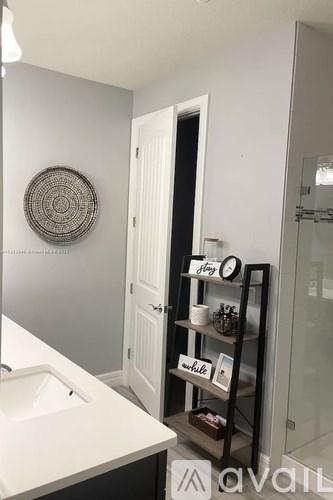 A bathroom with a white sink and a round decoration on the wall.