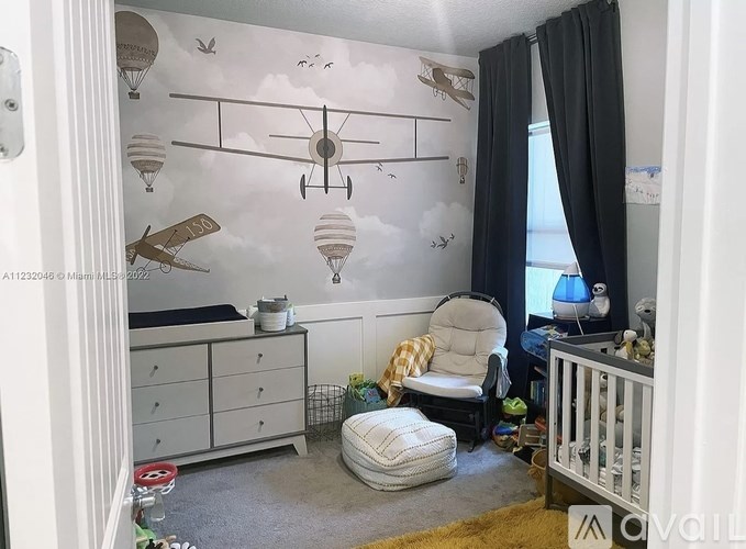A baby room with a wall mural of airplanes and a baby crib.