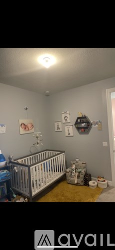 A baby nursery with a crib and a yellow rug.