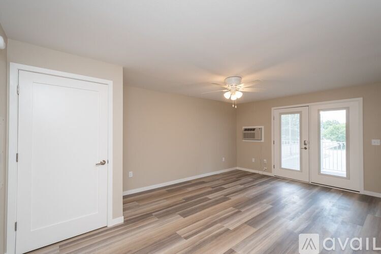 A room with wooden flooring and a white door.