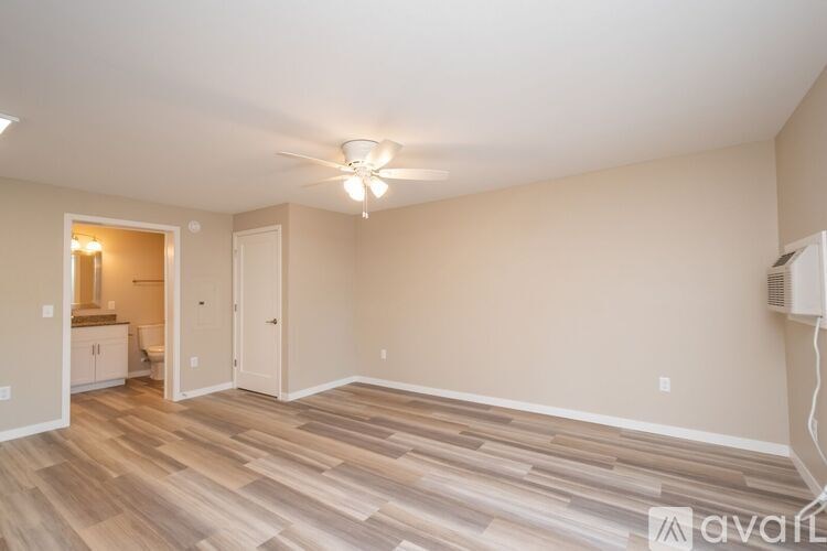 A room with wooden flooring and a ceiling fan.
