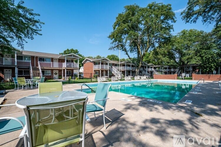 A sunny day at the poolside with chairs and tables arranged for relaxation.
