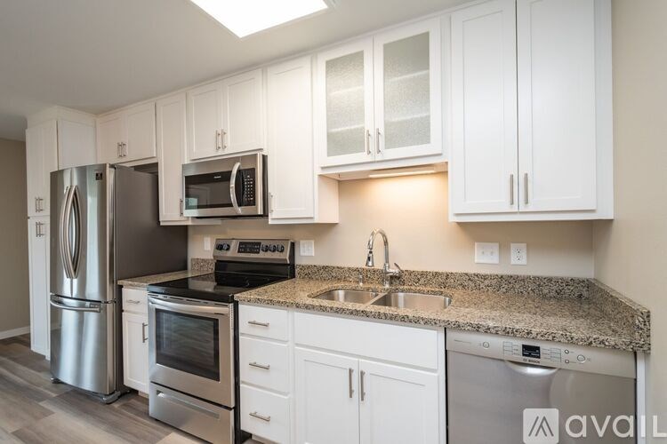 A kitchen with white cabinets and granite countertops.