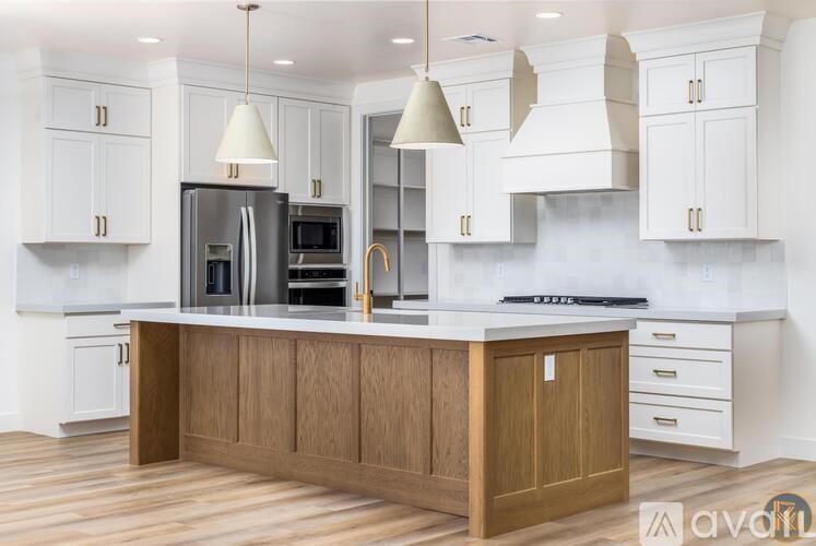 A kitchen with white cabinets and a wooden island.