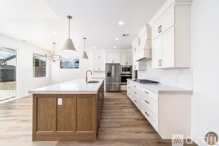 A modern kitchen with white cabinets and a wooden island.