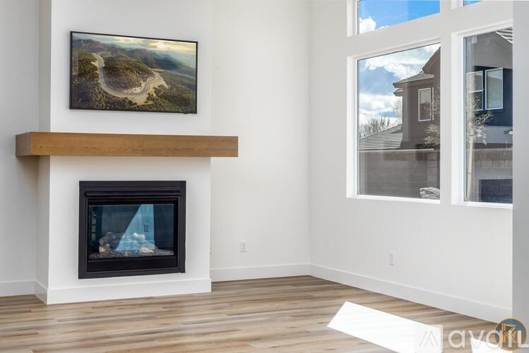 A modern living room with a fireplace and a painting on the wall.