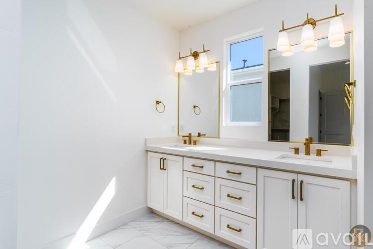 A bathroom with a vanity, a mirror, and a window.