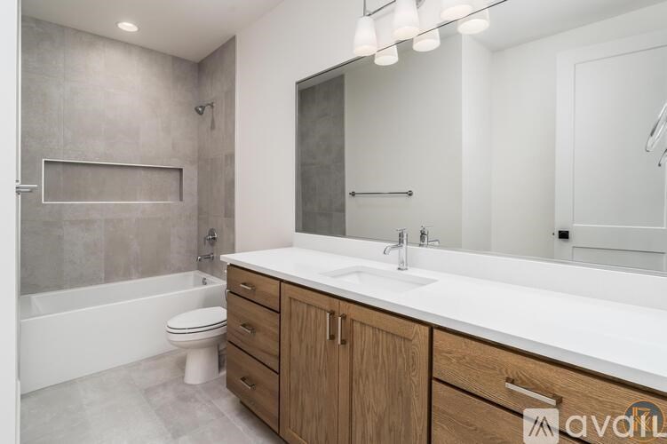 A bathroom with a white countertop and a wooden cabinet.