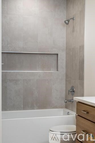 A bathroom with a white tub and a toilet.