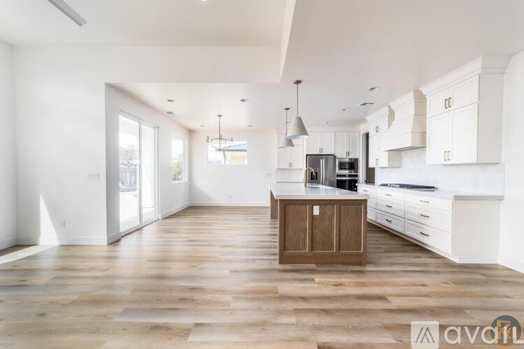 A kitchen with white cabinets and a wooden island.
