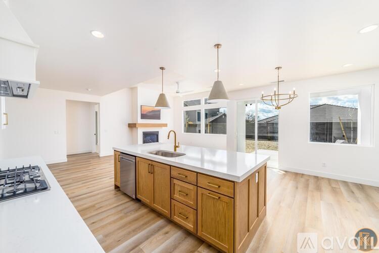 A modern kitchen with wooden floors and white countertops.