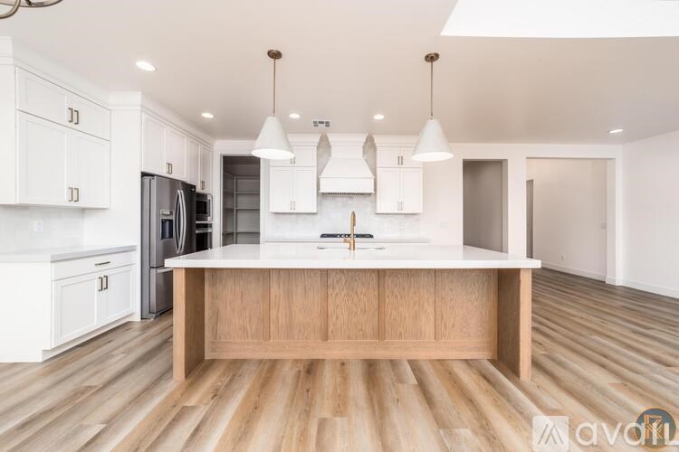A kitchen with white cabinets and a wooden island.