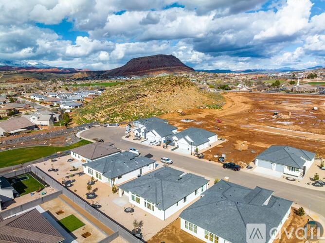 A bird's eye view of a residential area with houses and a dirt field.