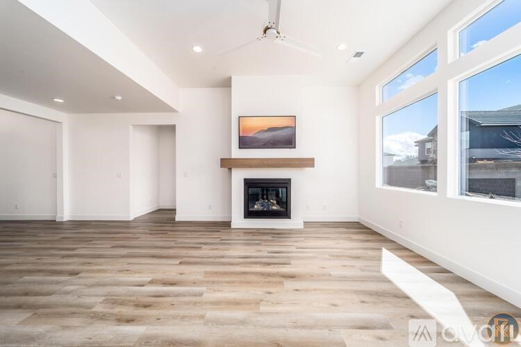 A modern living room with a fireplace and a painting above it.