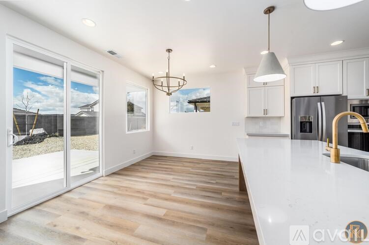 A modern kitchen with white cabinets and a wooden floor.