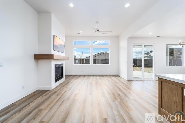 A spacious living room with wooden flooring and a large window.