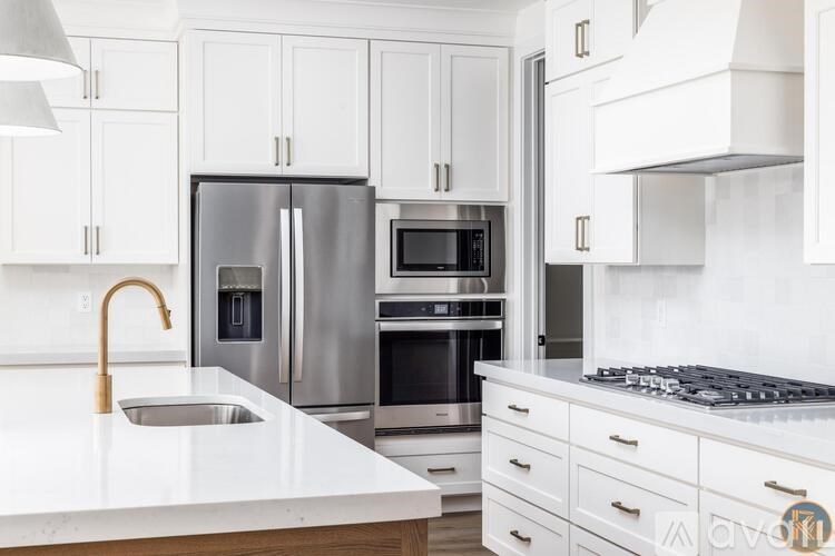 A modern kitchen with white cabinets and stainless steel appliances.
