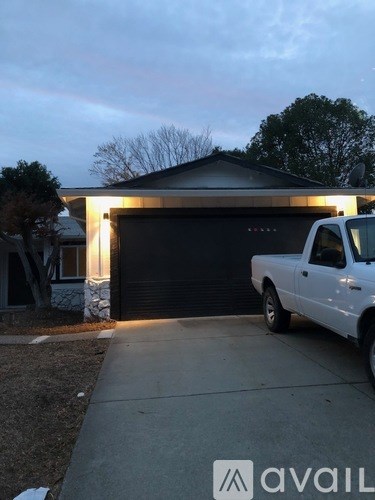 A white truck is parked in front of a black garage door.