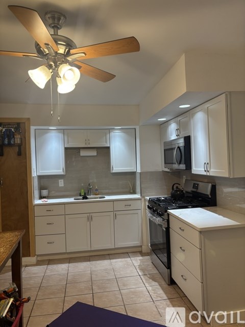 A kitchen with a fan and a stove top oven.
