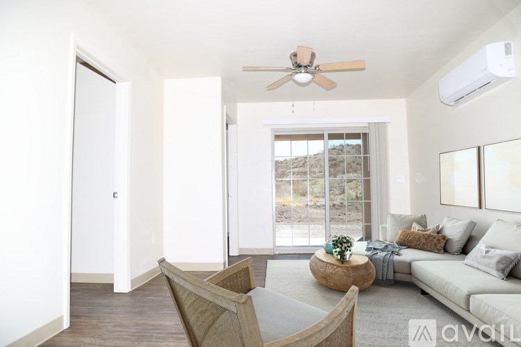 A living room with a couch, chair, and a ceiling fan.