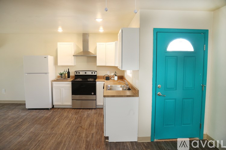 A kitchen with a blue door and white appliances.