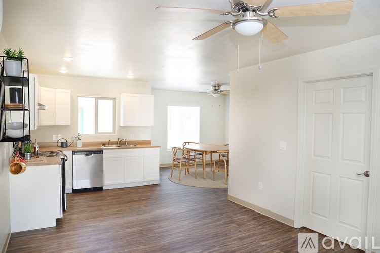 A kitchen with white cabinets and a wooden floor.