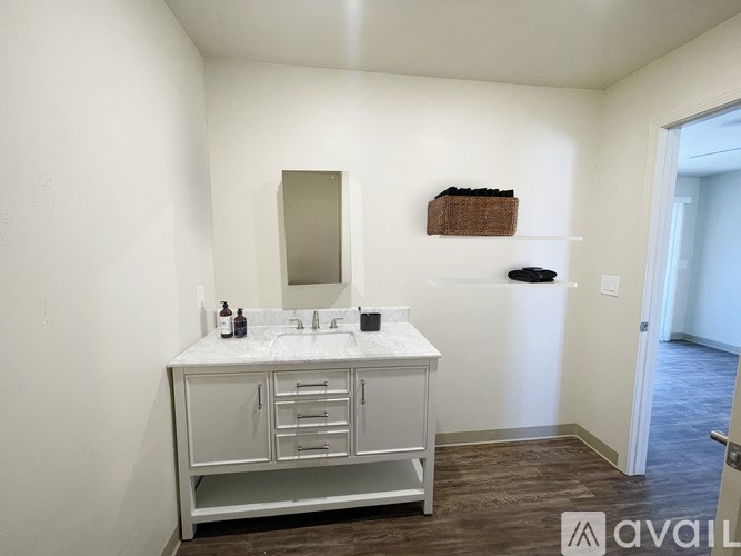 A bathroom with a white vanity and a mirror.