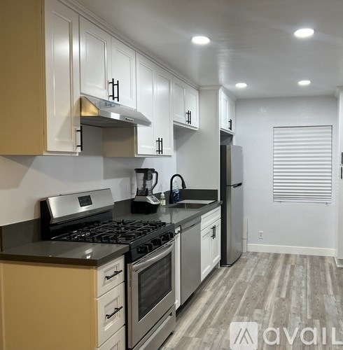 A kitchen with white cabinets and a black stove top.